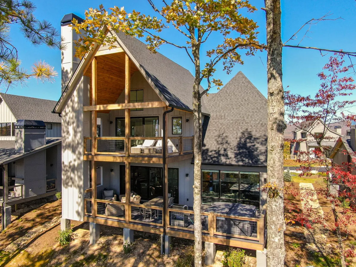 A welcoming balcony and wooden deck surrounded by tall trees, ideal for outdoor relaxing, dining, or gathering around a fire pit. The design invites residents and guests to unwind, socialize, and enjoy nature, echoing the camaraderie and fire pit gatherings mentioned in the section.