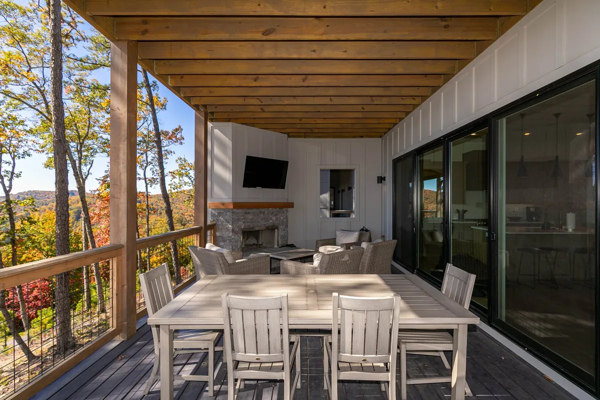 This shot highlights a cozy outdoor seating area featuring a fireplace, dining table, and comfortable chairs, all set against a natural landscape backdrop. The ambiance is intimate and inviting, ideal for evening wine by the fire or romantic outdoor meals.